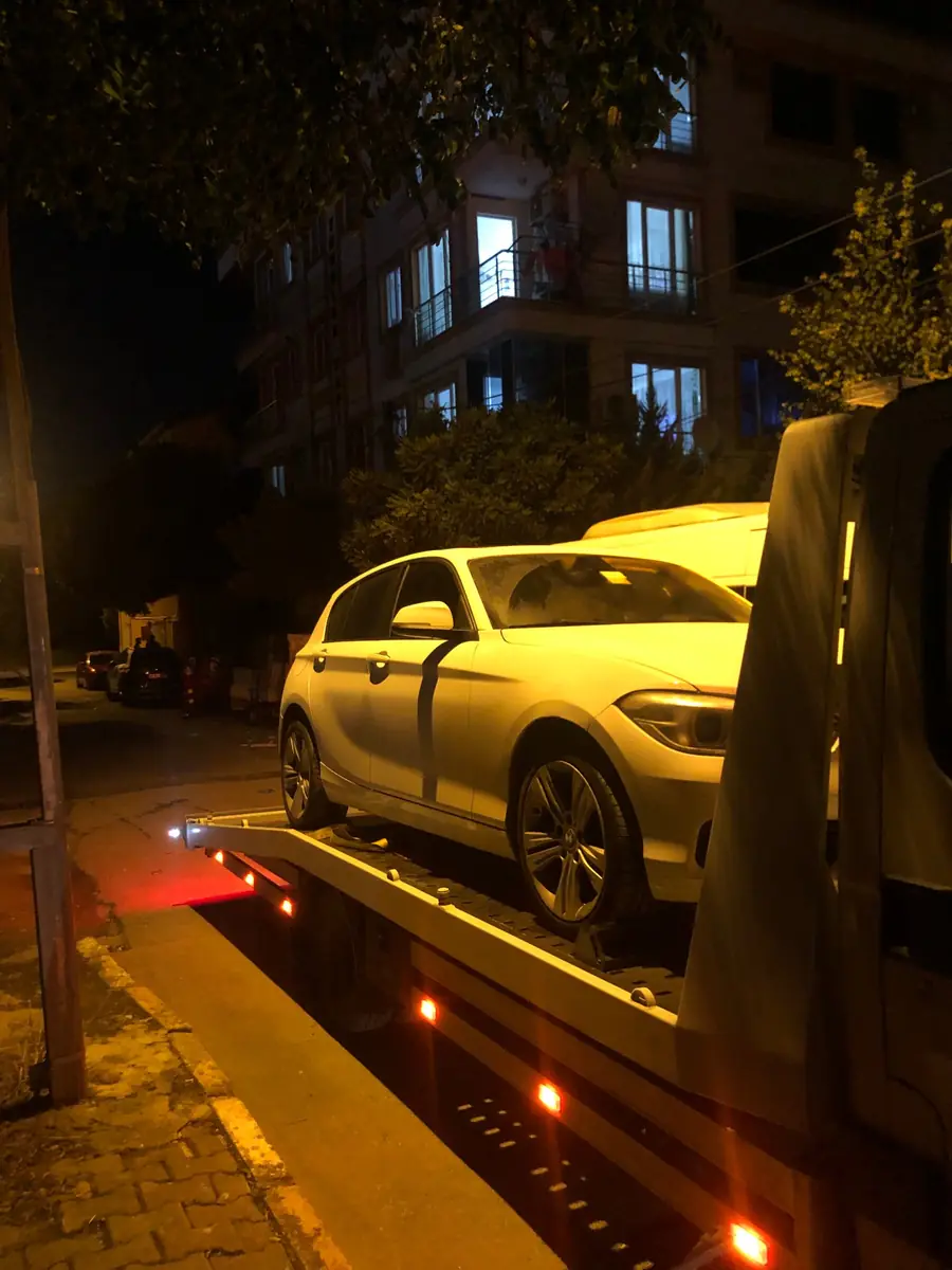 Gece apartman önünde kayar kasaya alınmış beyaz hatchback