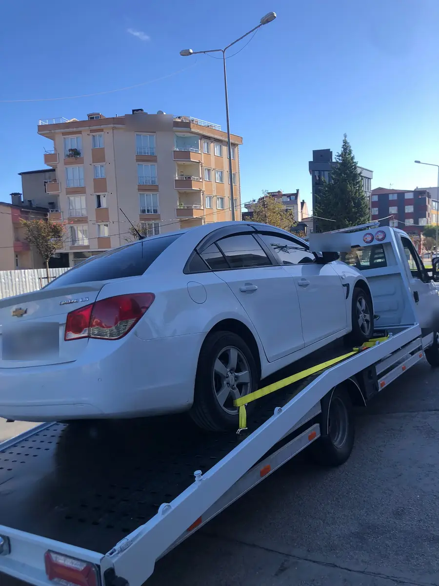 Kayar kasada tekerlek kayışıyla sabitlenmiş beyaz sedan